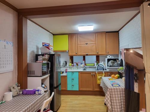 una piccola cucina con armadi in legno e tavolo di Lion's home 외국인 전용 a Seul