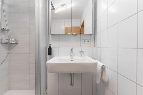 a white bathroom with a sink and a shower at Untersee-Suite IStayUnixI Seenähe-Terrasse-Workspace-Netflix-Parkplatz in Radolfzell am Bodensee