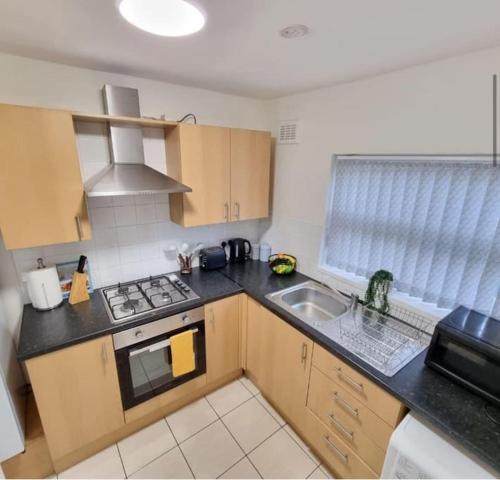 a kitchen with a sink and a stove top oven at Anfield 5 minutes walk sleeps 10 in Liverpool