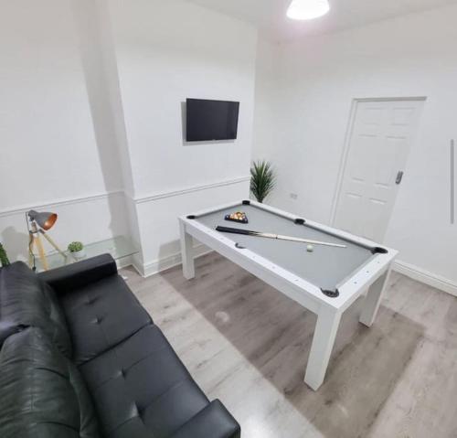 a living room with a pool table and a couch at Anfield 5 minutes walk sleeps 10 in Liverpool