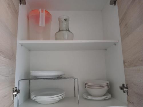a cabinet with plates and a vase on top at Casa en Playa Privada - A pocos minutos de General Villamil Playas in Posorja