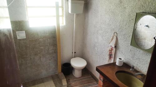 y baño con aseo, lavabo y espejo. en Sitio do Espigão, en Viamão