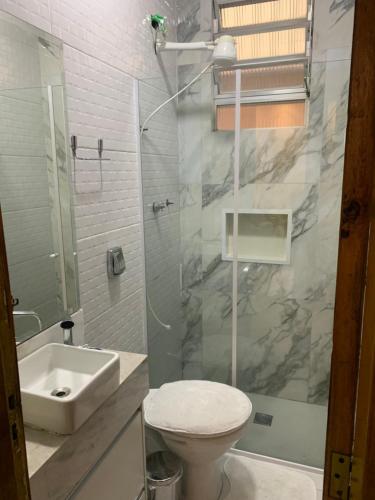 a bathroom with a sink and a toilet and a shower at Casa com churrasqueira Guilhermina Praia Grande in Praia Grande