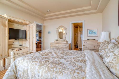 a bedroom with a large bed and a television at Arbor House North in Yachats