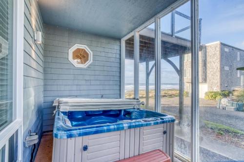 a bathroom with a blue tub in front of a window at Arbor House in Yachats