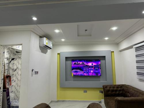 a living room with a flat screen tv on a wall at Wells Homes in Kwedonu