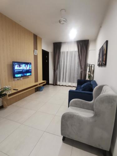 a living room with couches and a flat screen tv at K AVENUE B17 house room near airport by Gc in Kota Kinabalu