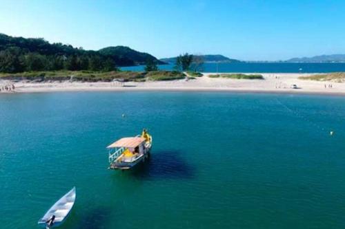 un bateau dans l'eau avec un bateau en papier dans l'établissement Casa Temporada Praia do Sonho, à Palhoça
