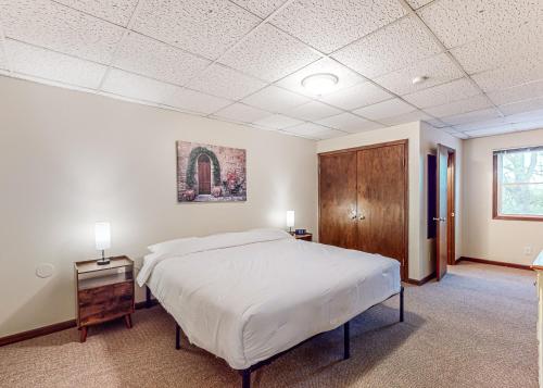 a bedroom with a large bed and a wooden cabinet at Baraboo's Enchantment - Main in Baraboo