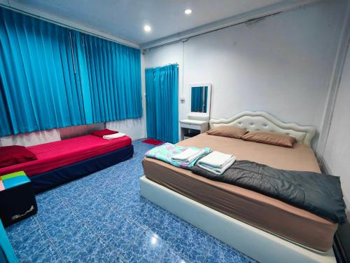 1 dormitorio con 2 camas y cortinas azules en Phangan Hostel Haadrin Homestay, en Haad Rin