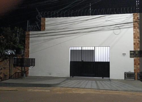 een witte muur met een zwarte poort erop bij APARTAMENTO CAUAMÉ in Boa Vista