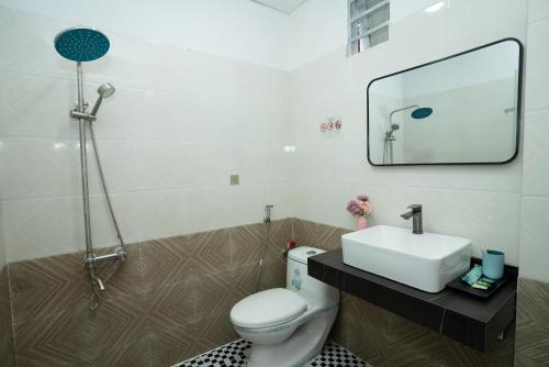 La salle de bains est pourvue d'un lavabo, de toilettes et d'un miroir. dans l'établissement EROS HOTEL, à Hô-Chi-Minh-Ville