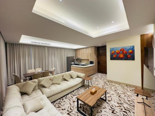 un soggiorno con divano bianco e una cucina di REMAZ ROSE BOULEVARD a Riyad