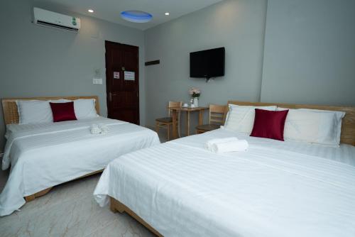 - deux lits assis l'un à côté de l'autre dans une pièce dans l'établissement EROS HOTEL, à Hô-Chi-Minh-Ville
