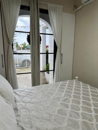 a white bed in a bedroom with a window at Benita At the Plaza in Dolores