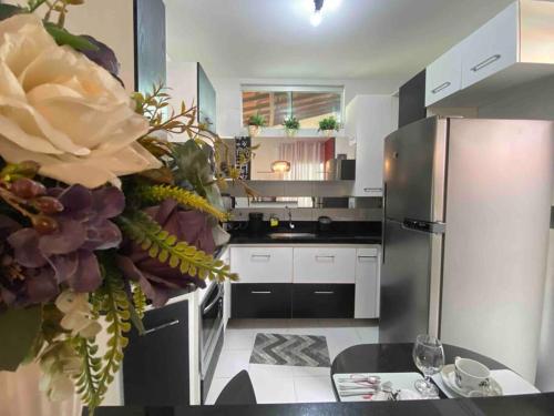 a kitchen with a stainless steel refrigerator and a table at Duplex em condomínio fechado in Campina Grande