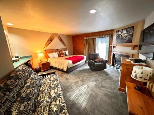 a hotel room with a bed and a couch and a desk at Whitetail Lodge in Saint Germain