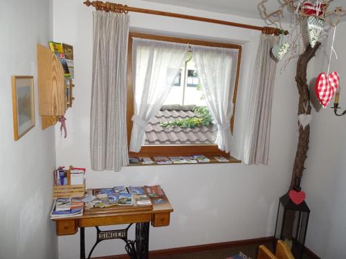 einen Schreibtisch in einem Zimmer mit einem Fenster und einem Tisch in der Unterkunft Haus Wiesengrund in Fulpmes
