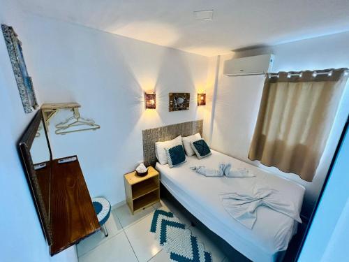 una piccola camera da letto con un letto e una finestra di Flats Corais a Maragogi