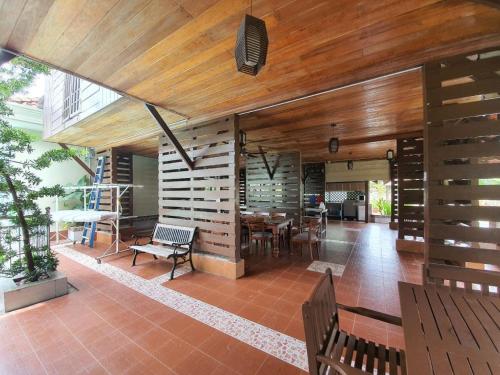 Alia Express Villa Temila Pasir Puteh في باسير بوته: غرفة بها طاولة وكراسي وجدران خشبية
