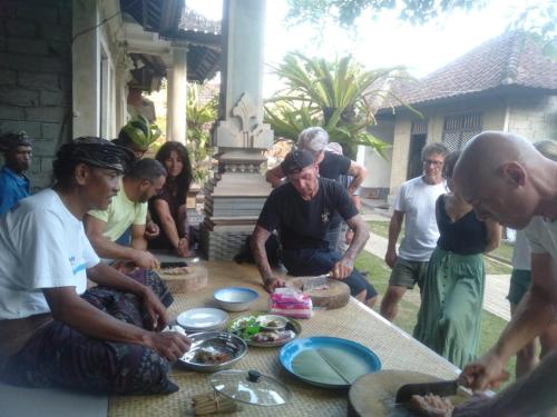 a group of people standing around a table with food at Pinge Traditional Village in Petang