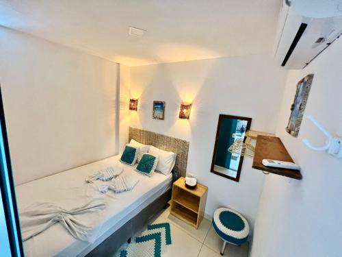 a small bedroom with a bed and a chair at Flats Corais in Maragogi
