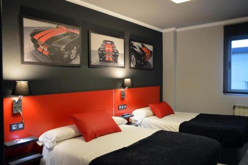 - 2 lits dans une chambre d'hôtel avec des photos sur le mur dans l'établissement HOTEL CEAO, à Lugo