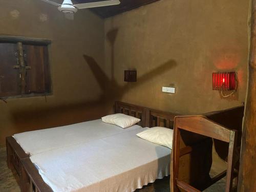 a bedroom with two beds and a red light on the wall at Pokuna River Chalet in Ratkarawwa