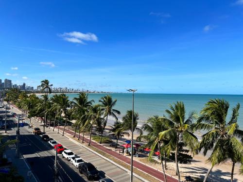 a view of a beach with palm trees and the ocean at FLAT PARTICULAR BEIRA-MAR DE CABO BRANCO edifício EASY GREEN SUNSET in João Pessoa