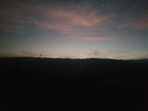 a silhouette of a field with the sunset in the background at Sipi Backpackers in Kapchorwa