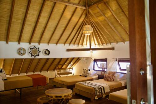 a room with two beds and a chandelier at Villa Sunset Beach in Gili Trawangan