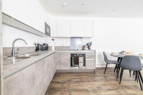 cocina con fregadero y mesa con sillas en City Escape - Unwind in Style en Barking