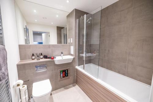 a bathroom with a toilet and a sink and a shower at City Escape - Unwind in Style in Barking
