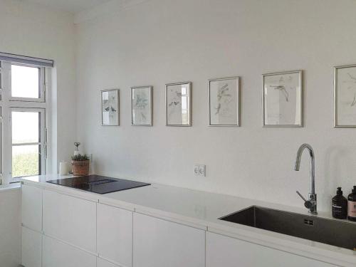 une cuisine avec un évier et quelques dessins sur le mur dans l'établissement Holiday home Assens IV, à Assens