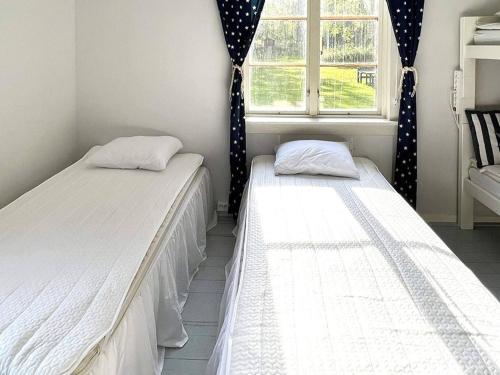 Duas camas num quarto com uma janela em Holiday home TRÖNÖDAL em Vallsta