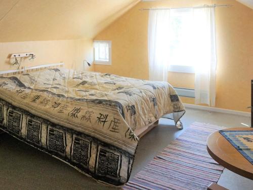 1 dormitorio con cama, ventana y alfombra en Holiday home TINGSRYD VI en Tingsryd
