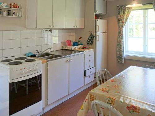 cocina con fogones, fregadero y mesa en Holiday home TINGSRYD VI en Tingsryd