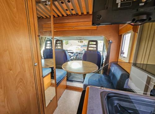 a dining area with a table in an rv at Sempre pronta para férias in Amadora