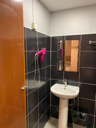a bathroom with a sink and a pink phone at GN Homestay Miri in Miri