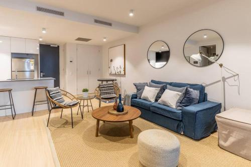 a living room with a blue couch and a table at West End Executive Suite, on the Brisbane River. in Brisbane