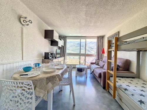 un salon avec une table et un lit dans l'établissement Studio rénové - Pied des pistes, balcon sud - FR-1-344-1193, aux Menuires
