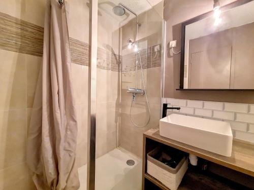 une salle de bain avec douche et lavabo dans l'établissement Studio rénové - Pied des pistes, balcon sud - FR-1-344-1193, aux Menuires