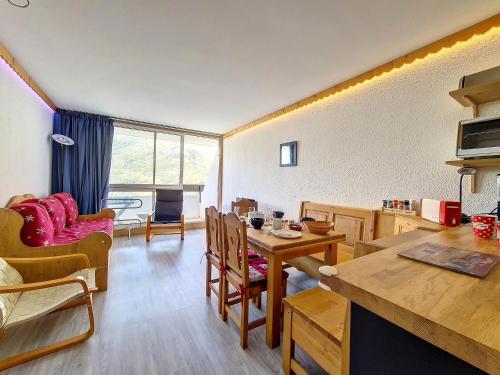 une cuisine et un salon avec une table et des chaises dans l'établissement Appartement lumineux 5 pers · Pied des pistes · Balcon sud · 2 flocons Argent - FR-1-344-1200, aux Menuires