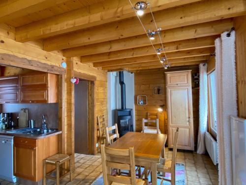 une cuisine et une salle à manger avec une table et des chaises en bois dans l'établissement Appartement 4 pièces, 8 pers, terrasse plein sud, parking, salle de jeux - FR-1-437-109, à La Clusaz
