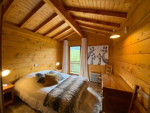 une chambre avec un lit dans une cabane en rondins dans l'établissement Appartement 4 pièces, 8 pers, terrasse plein sud, parking, salle de jeux - FR-1-437-109, à La Clusaz