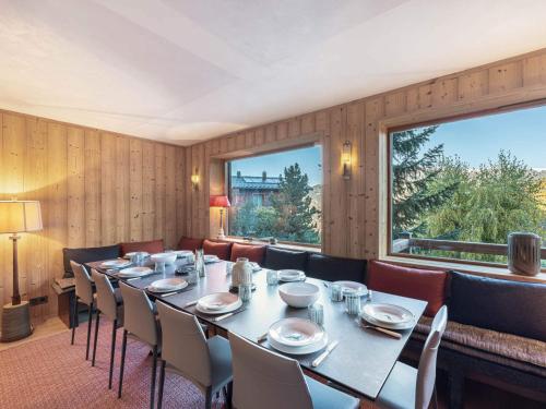 une salle à manger avec une table et des chaises et une grande fenêtre dans l'établissement Chalet spacieux 14 pers avec sauna, proche bus ski, garage, wifi, prestations incluses - FR-1-566-65, à Les Allues