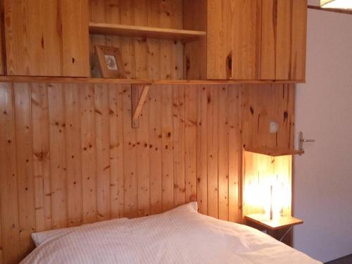- une chambre dotée d'un mur en bois avec un lit et une lampe dans l'établissement À Louer : Appartement 3 pièces, Pied des Pistes, Parking - FR-1-573-121, à Saint-Jean-dʼAulps