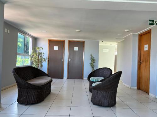 a lobby with two chairs and a hallway with doors at FLAT PARTICULAR BEIRA-MAR DE CABO BRANCO edifício EASY GREEN SUNSET in João Pessoa