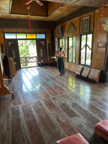 uma mulher a andar por um quarto com piso de madeira em Orchid Home em Ko Tao