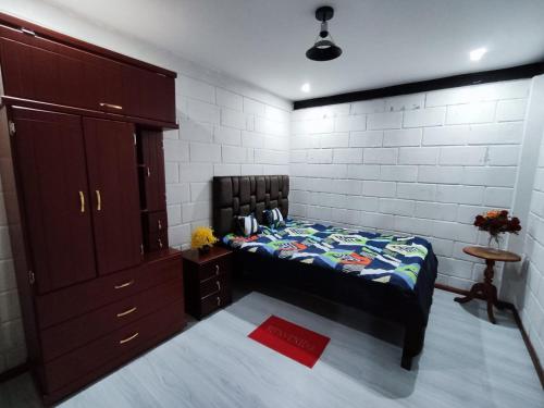 een slaapkamer met een bed, een dressoir en een kast bij Alojamiento Familiar MariaLuisa in Quillullaco